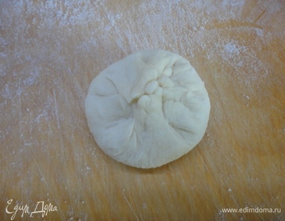 Каждую заготовку необходимо немного распластать, затем округлить, собирая края теста к центру.