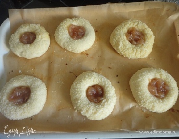 Затем сделайте в заготовках углубления для повидла. Для этого с помощью пестика ступки или конца скалки продавите середину сдобы до самого основания. Заполните углубления повидлом. Накройте пищевой пленкой и оставьте для расстойки еще на 60 минут.