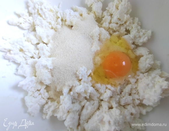 В творог добавить яйцо и манку.