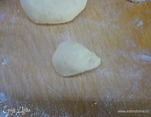 Подошедшее тесто выложите на стол, подпыленный мукой, и оставьте на 5 минут. Затем взвесьте и разделите на равные кусочки примерно по 100 г. Затем отделите от каждого маленький кусочек весом 20 г. Большие и маленькие кусочки сформуйте в шарики. У маленьких вытяните один конец.