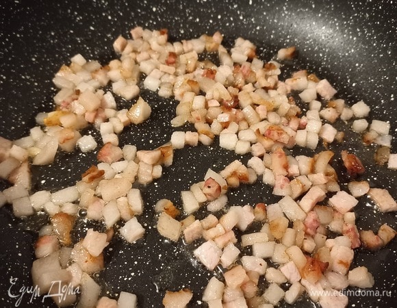 Далее отправляем в сковороду мелкие кусочки свиного продукта (бекон) и обжариваем до золотистой корочки.