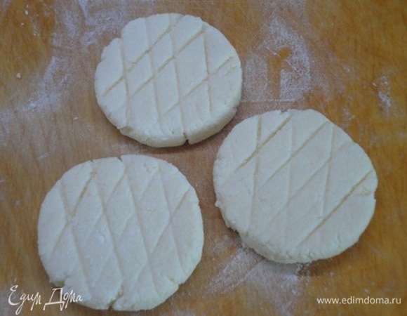 Разделить на 12 частей, хорошо обвалить в муке и с помощью ножа сформировать сырники. По желанию тупой стороной лезвия ножа можно нанести узор в виде решетки.