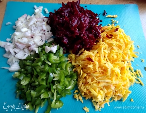 Натереть желтую морковь и свеклу, нарезать паприку и лук.