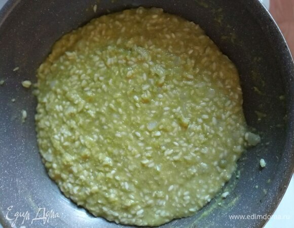 Добавляем гороховое пюре в рис частями и готовим, постоянно помешивая. Если кажется, что жидкости недостаточно, добавляем понемногу горячую воду или бульон. Готовим почти до готовности.