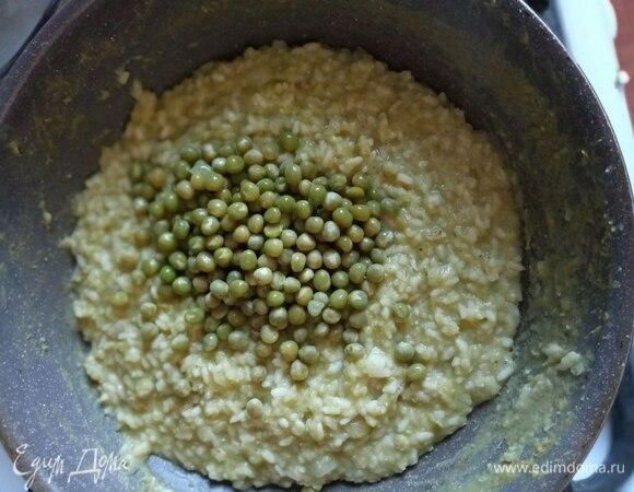 Добавляем 1\3 горошка. Перемешиваем и продолжаем готовить до готовности риса. Солим и перчим по вкусу.