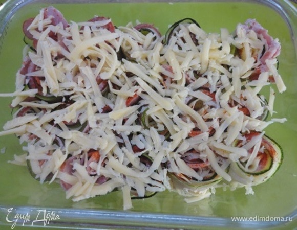 Оставшийся сыр натереть на терке и посыпать рулетики.