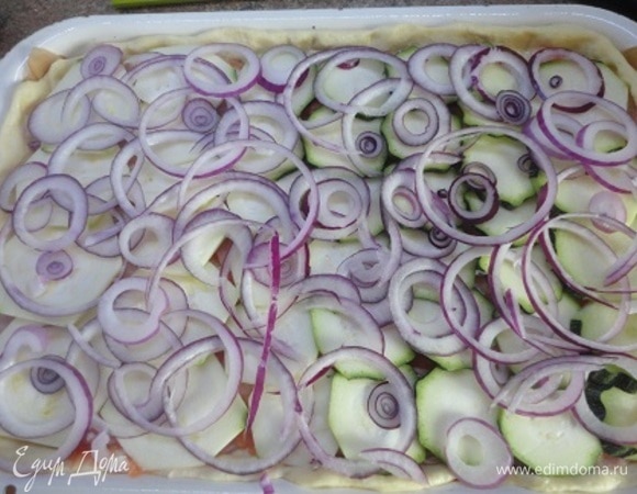 Сверху разложить кабачки и лук.
