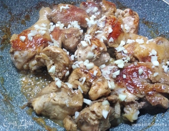 Убрать тарелку, курицу перевернуть, посыпать рубленым чесноком. Жарить 10 минут.