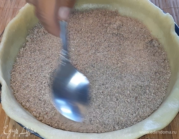 На дно теста насыпьте шоколад, натертый на крупной терке. Перед тем как натереть, сильно охладите его.