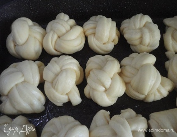 Автор рецепта рекомендует противоположные концы косичек подогнуть вниз и уложить в металлические формочки для кексов. У меня таких нет, поэтому я выложила булочки на противень. Получилось 18 штук.