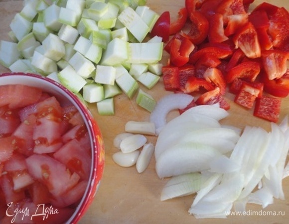 Курицу нарежьте порционными кусками. Кабачки и перец нарезать крупными кубиками. Лук — полукольцами. Чеснок разрезать на несколько долек. Помидоры очистить от кожицы и нарезать кубиками.