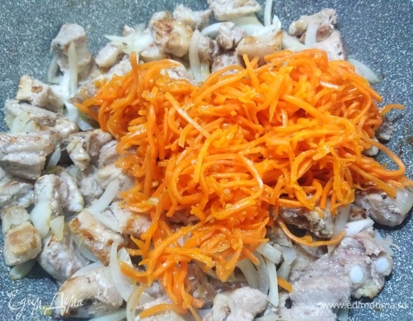 Добавить морковь по-корейски. Жарить 12–15 минут, помешивая.