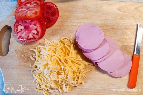 Колбасу и помидоры нарезать кружочками, сыр натереть на крупной терке.