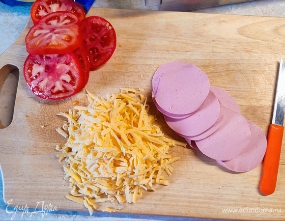 Колбасу и помидоры нарезать кружочками, сыр натереть на крупной терке.