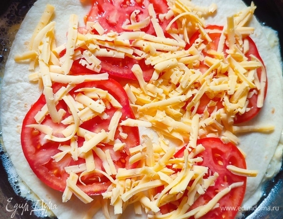 Выложить помидоры, посыпать сыром, накрыть тортильей и повторить слой с колбасой. Накрыть последней тортильей и сверху вылить взбитое одно яйцо.