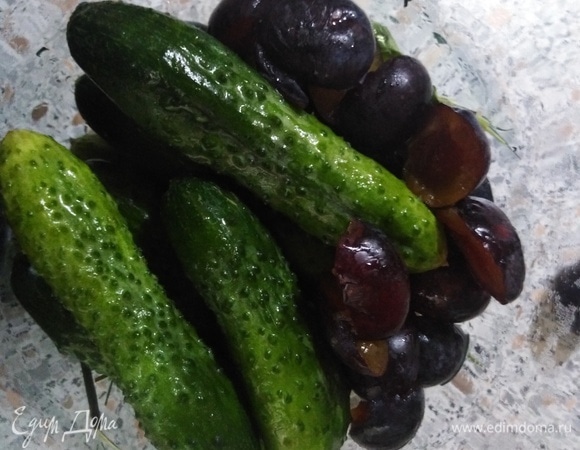 На дно банки выложить специи, затем огурцы и сливы без косточек.