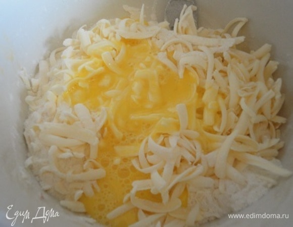 Просеять муку в глубокую миску. Добавить разрыхлитель, сахар, ванильный сахар, соль и хорошо перемешать. Натереть холодное масло, добавить желток и перетереть все руками до состояния крошки.