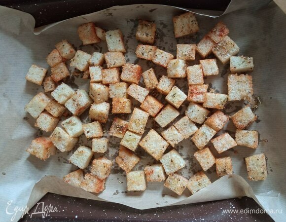 Для сухариков нарезаем белый хлеб на кубики. Поливаем его маслом, добавляем прованские травы, паприку, соль и немного измельченного чеснока. И тщательно перемешиваем. Пересыпаем на противень или в форму для выпечки на лист бумаги, равномерно разравниваем. Отправляем подсушиться в духовку на 10–15 минут при 150°C.