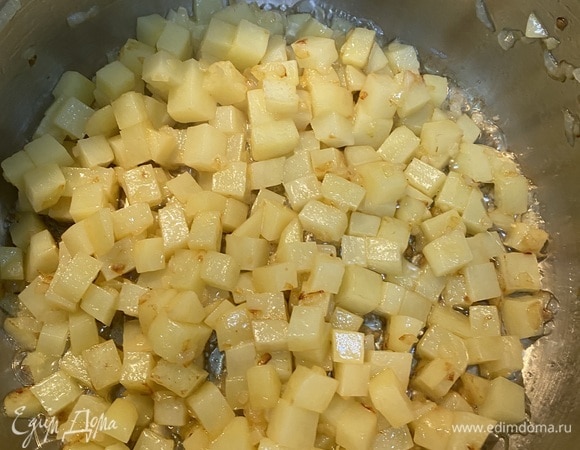 Очистить и подготовить картофель и грибы. Картофель нарезать ровными кубиками, около 1 см. Шампиньоны — тонкими слайсами. Лисички разрезать вдоль на две части. Лук мелко нашинковать. Разогреть кастрюлю, где будет вариться суп, и положить в нее 20 г масла. Обжарить в нем лук до золотистого цвета и добавить картофель. Обжарить картофель до золотистого цвета, не забывая перемешивать.