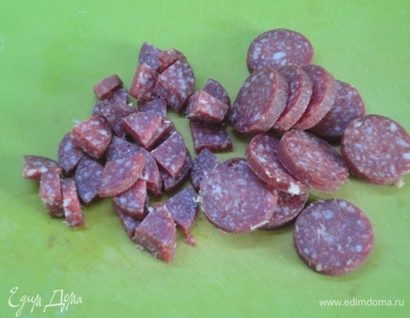 Фасоль без предварительного замачивания промыть и поместить в сотейник. Залить водой на 5 см выше уровня фасоли, довести до кипения и варить с закрытой крышкой на медленном огне 1 час. Нарезать колбасу небольшими кусочками .