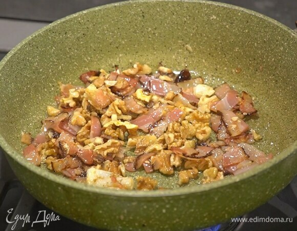 Разогреть в глубокой сковороде 1–2 ст. ложки оливкового масла, выложить чеснок, панчетту, перец чили, грецкие орехи и перемешать.