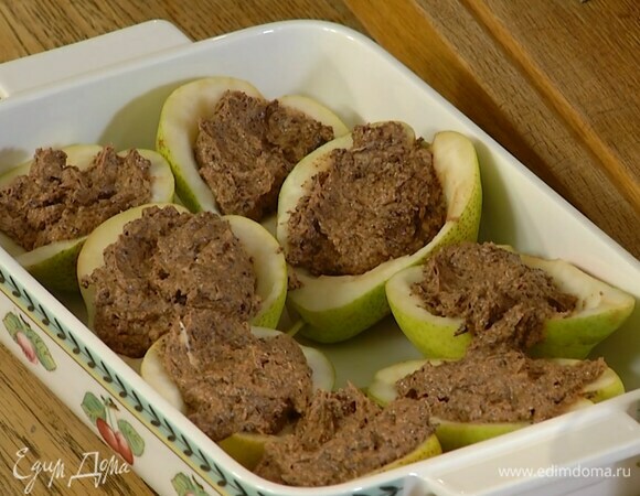 Выложить половинки груш в жаропрочную керамическую форму срезами вверх и наполнить шоколадной массой, влить на дно формы 100 мл горячей воды и запекать в разогретой духовке 30–35 минут.