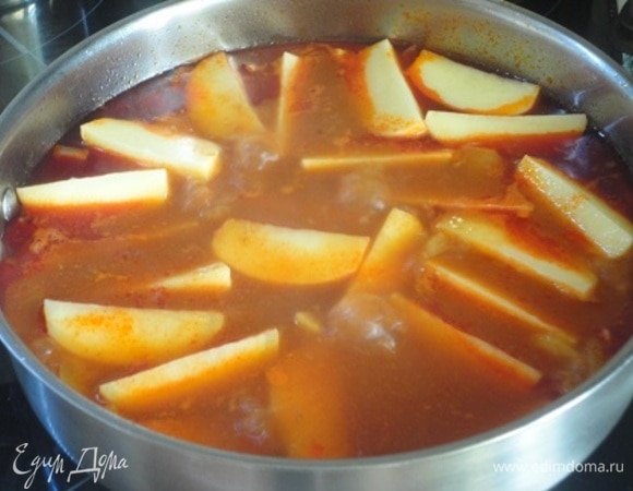 Очищенный картофель нарезаем «чесночком» и добавляем в сотейник к мясу. Доводим до кипения, уменьшаем нагрев и продолжаем тушить до готовности картофеля.