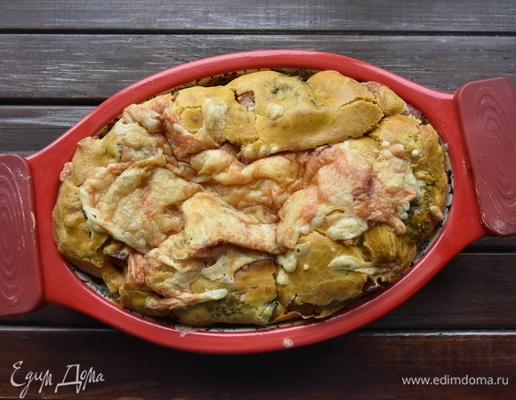 Поместите форму с тестом в духовку и выпекайте пирог 40 минут. За 5 минут до готовности нанесите на поверхность пирога часть оставшегося сыра, натертого на терке.