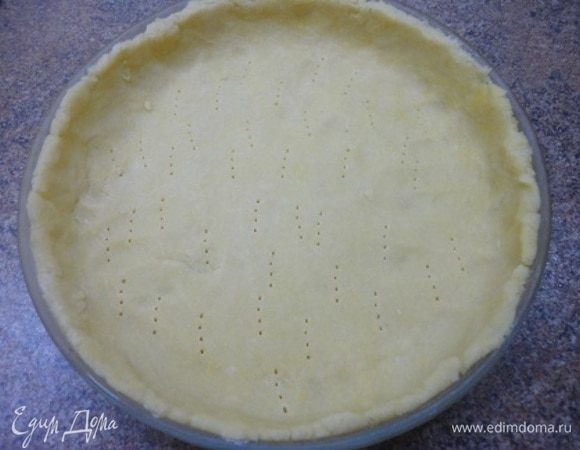 Включить духовку для разогрева до 180°C. Охлажденное тесто раскатать в круг и уложить в смазанную маслом форму диаметром 23–24 см. Наколоть вилкой и выпекать 15 минут при 180°C. Остудить.