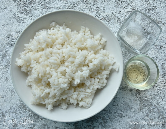 Отварите рис. В кипящую воду засыпьте рис в соотношении 1,5:1. Накройте посуду крышкой и уменьшите огонь до минимума. Варите крупу на минимальном огне 20 минут. После чего отключите нагрев и оставьте рис дойти под крышкой еще минут 10. После чего взрыхлите рис вилкой. Для заправки смешайте рисовый уксус, соль и сахар. Влейте в крупу и перемешайте.