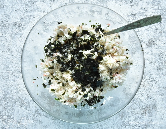 Водоросли нори измельчите и добавить к рису вместе с кунжутом и мелко нарезанным свежим огурцом. В одну часть риса добавьте мелко нарезанное крабовое мясо. Во вторую часть риса добавьте мелко нарезанного лосося. Все хорошо перемешайте, чтобы компоненты равномерно распределились.