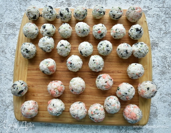 Из рисовой массы сформируйте шарики размером с небольшой грецкий орех. Скатывать роллы удобнее, периодически увлажняя руки водой с лимонным соком.