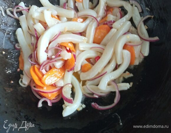 Кальмаров предварительно размораживаем. Если у вас охлажденные, то чистим от пленок и хитиновой пластины. Кольца я разрезала на две части. Кальмара можно нарезать на не очень широкие прямоугольники и чуть-чуть (не прорезая до конца) нанести ромбовидную сетку. Тогда при приготовлении они немного свернутся в трубочку и будут похожи на маленькие початки кукурузы. Добавляем нарезанные кальмары к овощам и жарим, постоянно помешивая, 1 минуту.