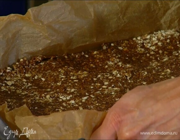 Небольшую форму выстелить бумагой для выпечки и равномерно выложить овсяную массу.