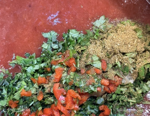 Протираем сливы и получившийся сок через сито в кастрюлю. Добавляем соль, сахар, мелко нарезанный перец, чеснок, травы и хмели-сунели. Ставим кастрюлю на средний огонь, постоянно помешивая, доводим до кипения и варим на медленном огне 10 минут.