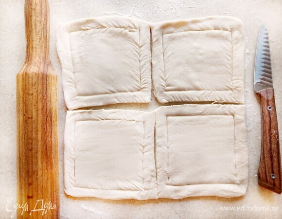 Разморозьте упаковку слоеного дрожжевого теста (2 пласта). Слегка раскатайте и каждый пласт теста разрежьте на 4 части. В каждом из получившихся квадратов по периметру сделайте надрезы, отступая от края 1,5 см.