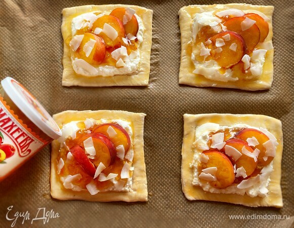 Затем по 1 ст. л. джема ТМ «МАхеевъ», сверху уложите дольки персика и посыпьте кокосовой стружкой (у меня кокосовые кранчи). Бортики смажьте яйцом (можно только желтком). Поставьте в духовку, разогретую до 200°C минут на 35–40 до золотистой корочки.
