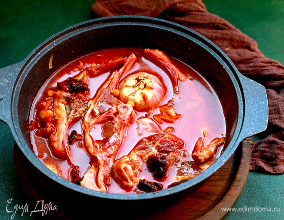 Залить кипятком, чтобы практически покрывал мясо. Добавить головку чеснока. Верх закрыть крышкой или затянуть фольгой, запекать 2 часа в разогретой духовке.