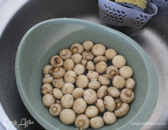 Грибы шампиньоны хорошо промыть под проточной водой. Совет: замочить грибы на непродолжительное время в холодной воде в миске, чтобы отошла грязь, если имеется. Обычно хватает 5–10 минут, потом снова хорошо промыть водой.