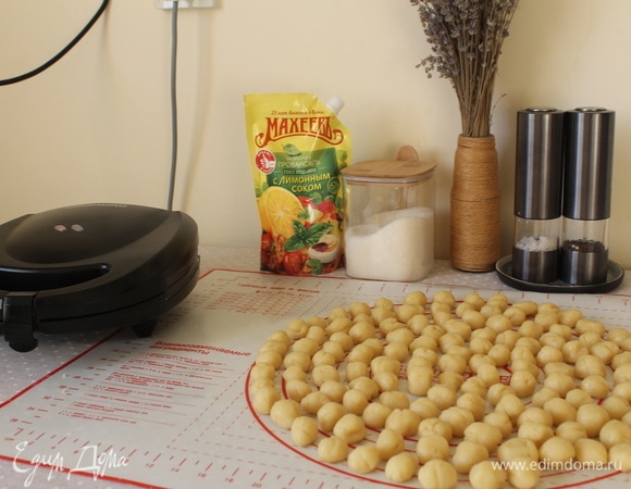 Скатываем из каждого кусочка маленький шарик. Вес каждого шарика у меня 7–8 граммов (таков вес для моей орешницы, вы ориентируйтесь на свою). Совет: лучше сначала взвесить пробный шарик на кухонных весах, для того чтобы знать какого примерно размера катать шарики. Если теста мало, орешки будут маленькие и неровные, а если много, то тесто вылезает за края формочки для скорлупки. Совет: опыт показал, что лучше сформировать сразу все шарики из всего теста, так как скорлупки очень быстро выпекаются.