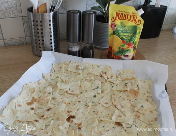 Нарезать смазанный лаваш на полоски, затем на квадратики. Выложить на застеленный пергаментом противень. Отправить в духовку, разогретую до 180°C, на 10 минут (+-). Нужно следить, чтобы не подгорели.