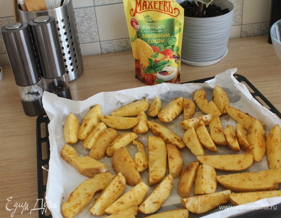 Выложить картофель на противень, застеленный пергаментной бумагой.