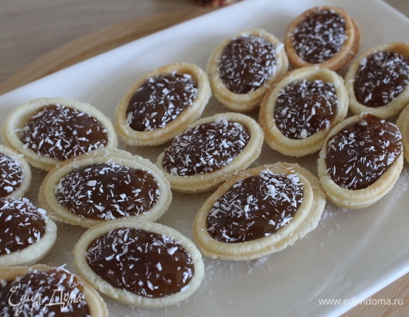 В скорлупки положить необходимое количество начинки. В качестве начинки я использовала топинг «Мягкая карамель» ТМ «Махеевъ». Выкладываем красиво на блюдо, украшаем по своему вкусу. Я посыпала кокосовой стружкой. Можно по желанию в каждый положить по орешку, тоже будет очень вкусно.