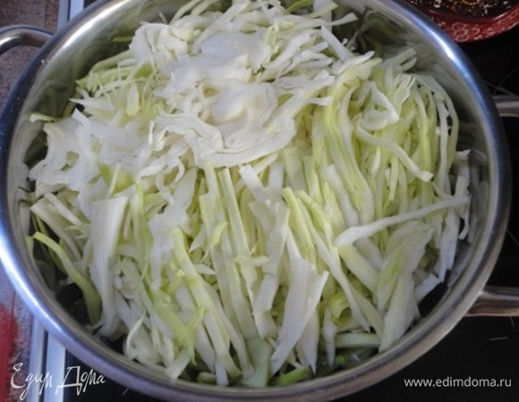 Капусту нашинковать, уложить в кастрюлю, залить крутым кипятком и накрыть крышкой. Оставить на 15 минут.