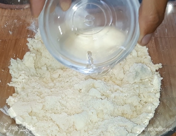 Влейте ледяную воду, лимонный сок и замесите тесто.