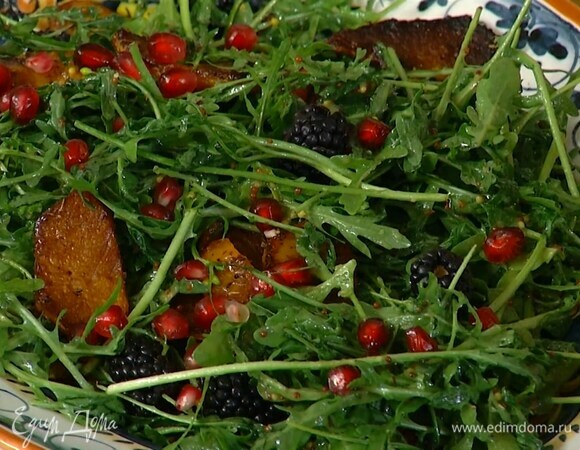 Руколу смазать заправкой и выложить на тыкву, посыпать зернами граната и ежевикой.