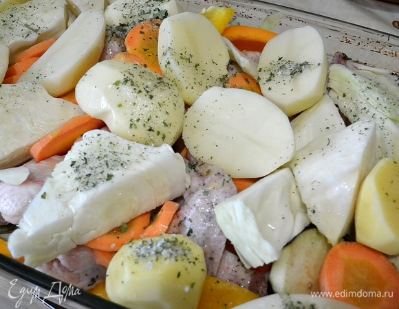 Нарезать все овощи на крупные кусочки. Противень смазать оливковым маслом. Сложить вниз куриные крылья, затем хаотично положить овощи.