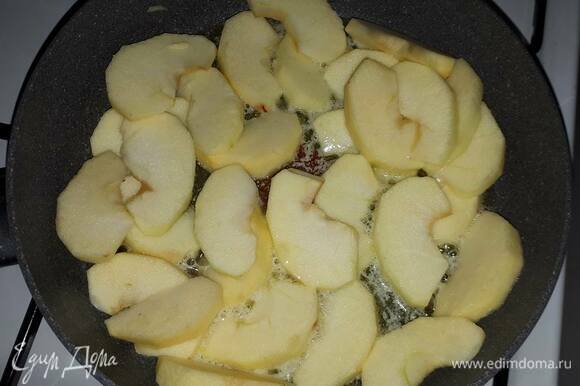 Для приготовления карамелизированных яблок очистите и нарежьте яблоки на дольки. Немного поджарьте со всех сторон на растопленном масле и всыпьте сахар.