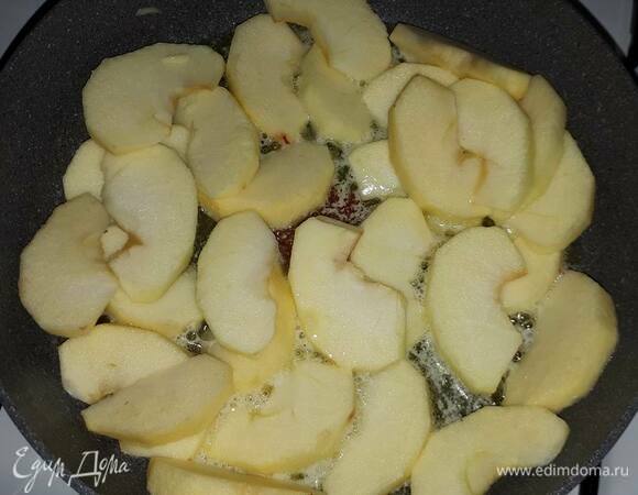 Для приготовления карамелизированных яблок очистите и нарежьте яблоки на дольки. Немного поджарьте со всех сторон на растопленном масле и всыпьте сахар.