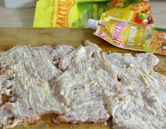 Филе бедра индейки отбить в тонкий пласт. Берите именно бедро — оно самое сочное. Когда отбиваете мясо, обязательно прикрывайте пищевой пленкой, так вы избавите себя от генеральной уборки на кухне. Отбитое мясо покройте смесью майонеза, горчицы и свежемолотого перца. Дайте промариноваться 30 минут минимум.